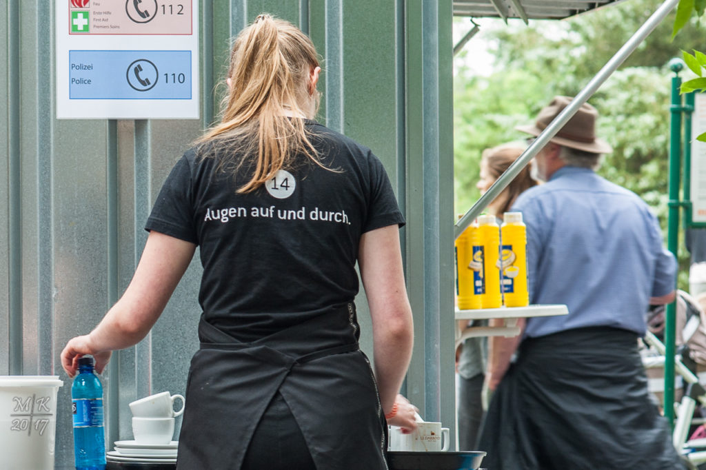 Servicemitarbeiterin der documenta 14 mit Logo "Augen auf und durch." auf dem T-Shirt.